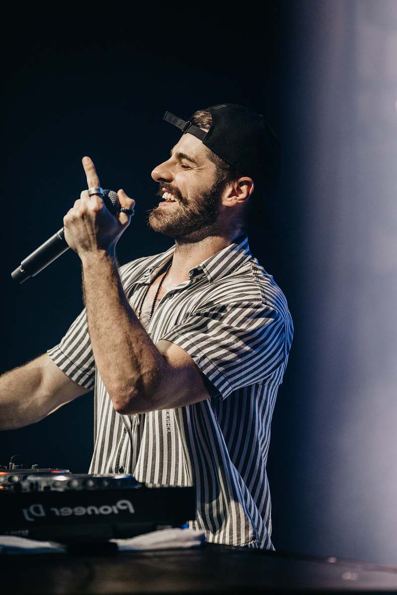 human man in gray and black shirt holding microphone person